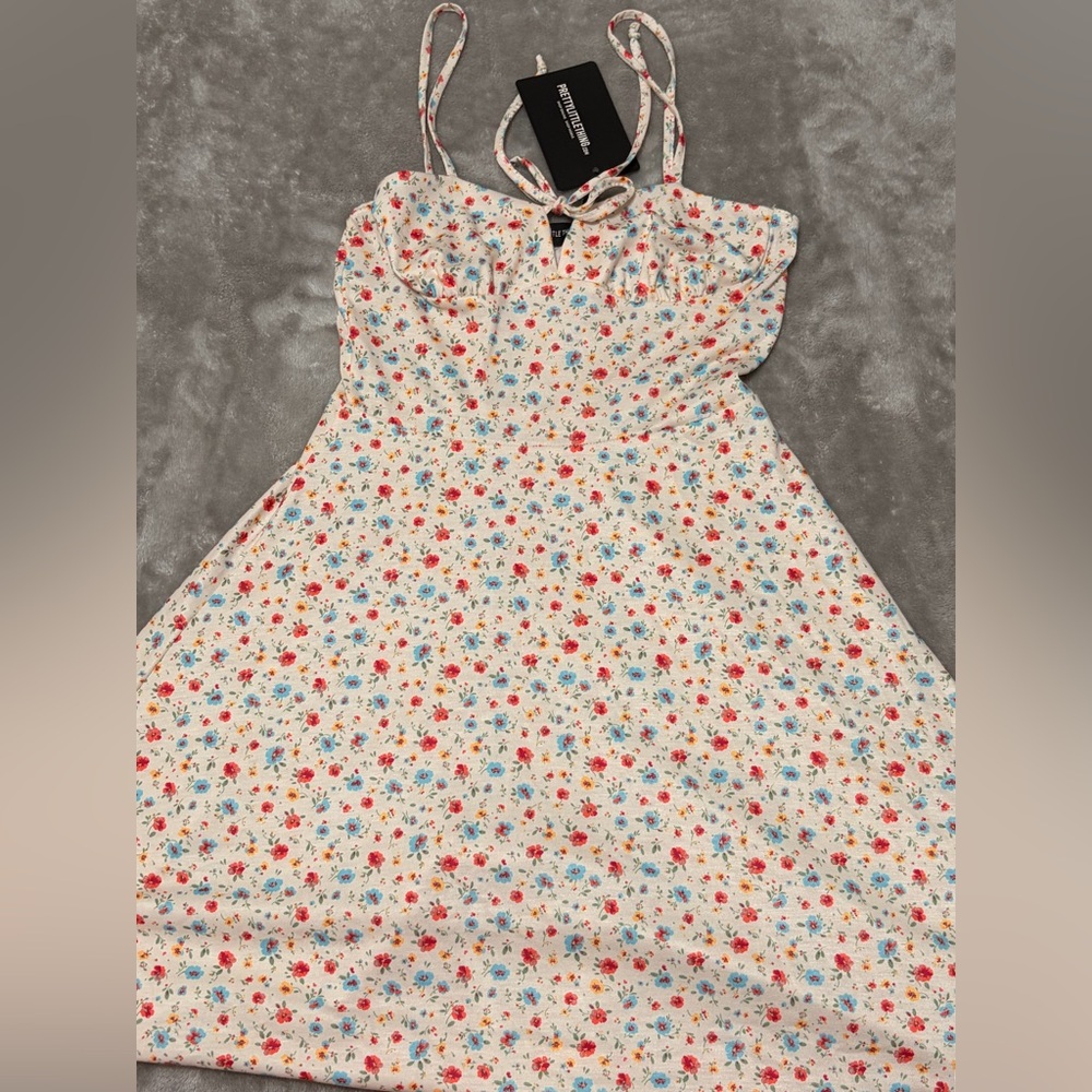 PrettyLittleThing cream ditsy floral tie front skater dress.